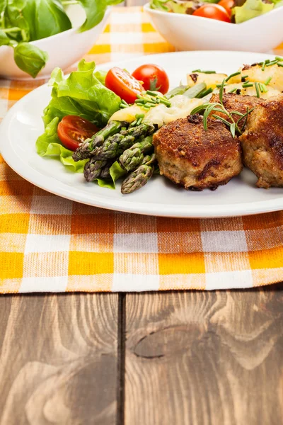 Köttbullar serveras med kokt potatis och sparris — Stockfoto