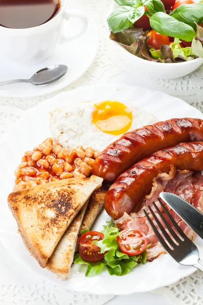 Englisches Frühstück mit Speck, Wurst, Spiegelei und gebackenen Bohnen — Stockfoto