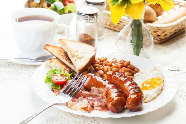 Komplett engelsk frukost med bacon, korv, stekt ägg och bakas — Stockfoto