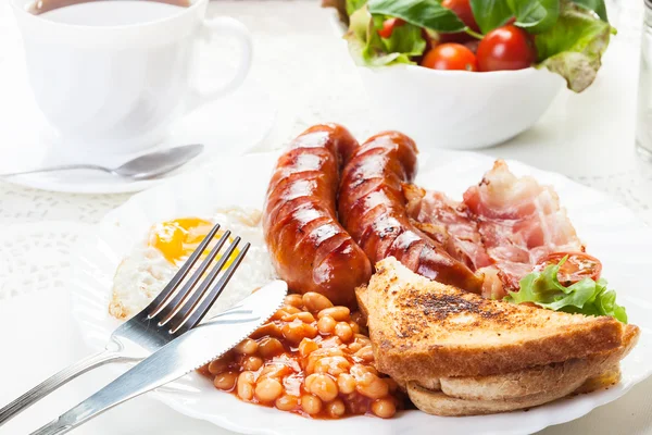 Komplett engelsk frukost med bacon, korv, stekt ägg och bakas — Stockfoto