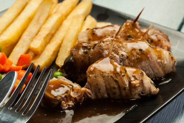 Rolos de porco com batatas fritas com legumes — Fotografia de Stock