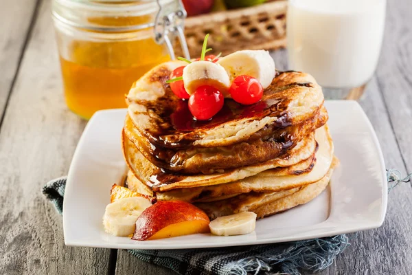 Frittelle con salsa di cioccolato frutta e vetro di latte — Foto Stock