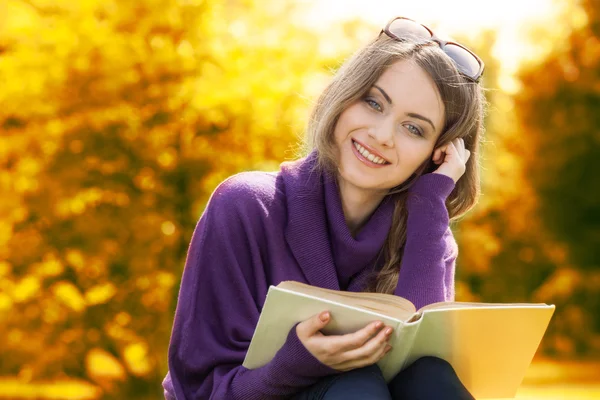 Frau liest Buch in herbstlicher Landschaft — Stockfoto
