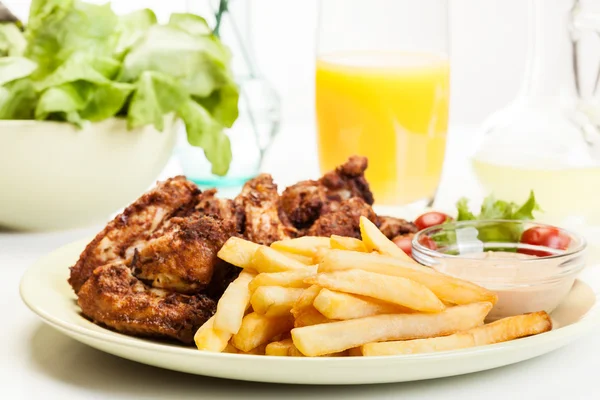 Kippenvleugels met frietjes Franse en pikante saus — Stockfoto