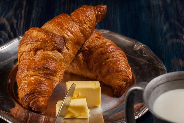 Croissants with butter and a glass of milk — Stock Photo, Image