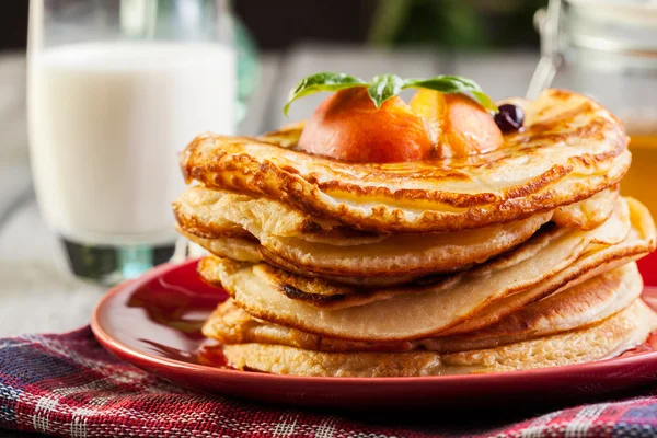 Panquecas com mel, fruta e copo de leite — Fotografia de Stock