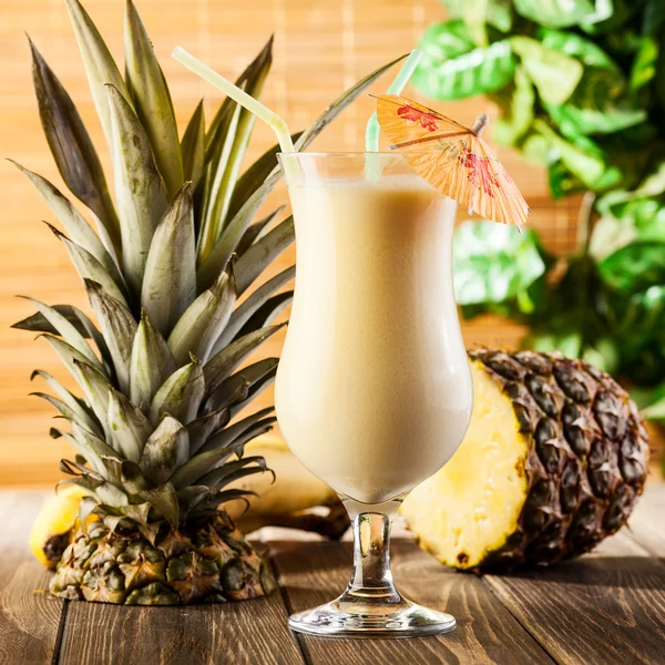 Pina colada op houten achtergrond gegarneerd ananas — Stockfoto