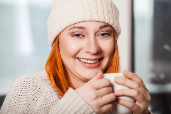 Woman wearing warm clothing and drinking hot drink — Stock Photo, Image