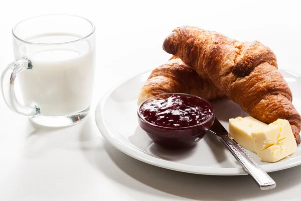 Fresh croissants with butter and a glass of milk — Stock Photo, Image