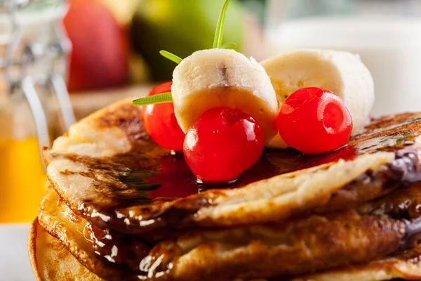 Pancakes with chocolate sauce fruit and glass of milk — Stock Photo, Image