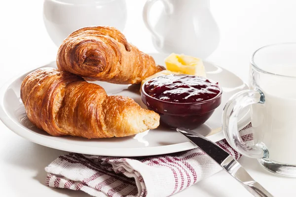 Fresh croissants with butter and a glass of milk — Stock Photo, Image