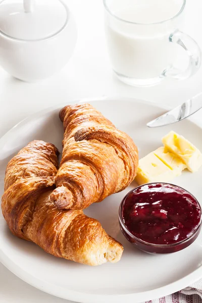 Croissants with butter and a glass of milk on a plate — Stock Photo, Image