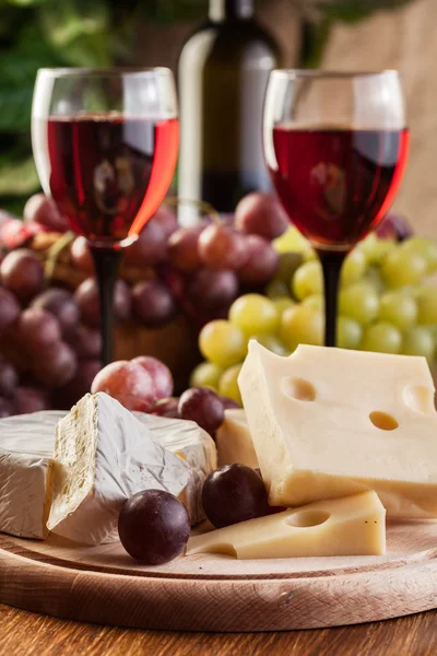 Formaggio con bottiglia e bicchieri di vino rosso — Foto Stock