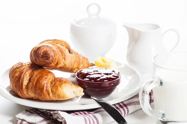 Croissants with butter and a glass of milk on a plate — Stock Photo, Image