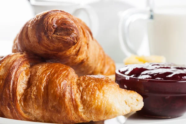 Croissants with butter and a glass of milk on a plate — Stock Photo, Image