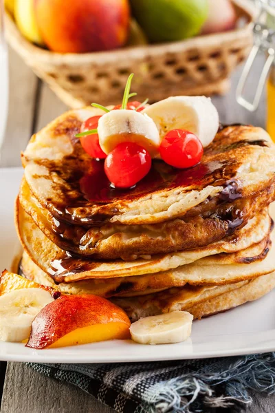 Pancakes with chocolate sauce fruit and glass of milk — Stock Photo, Image