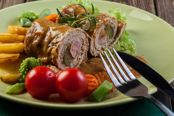 Rolos de porco com batatas e legumes preparados — Fotografia de Stock