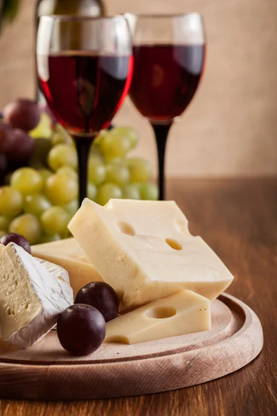 Formaggio con bottiglia e bicchieri di vino rosso — Foto Stock