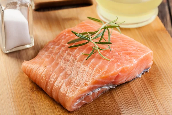 Filet de saumon cru sur planche à découper en bois — Photo