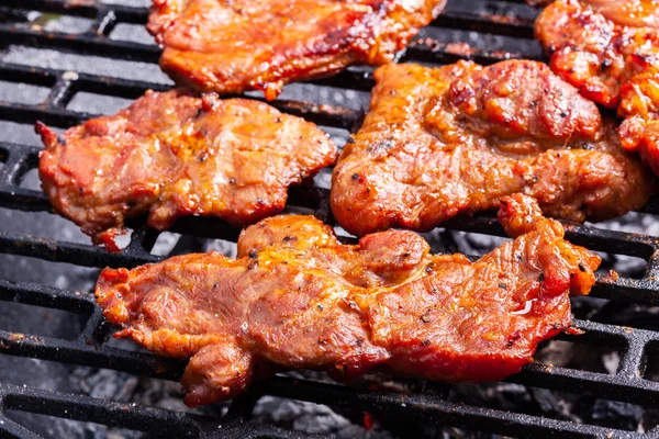 Asar filetes de cerdo en la parrilla de barbacoa —  Fotos de Stock