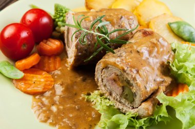 Pork rolls with prepared potatoes and vegetables clipart
