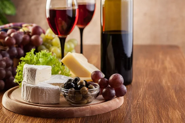 Cheese with a bottle and glasses of red wine — Stock Photo, Image