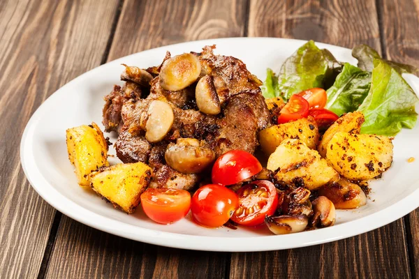 Gebratenes Schweinekotelett mit Champignons und Pommes — Stockfoto