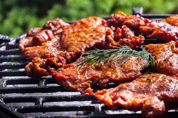 Grilling pork steaks on barbecue grill — Stock Photo, Image