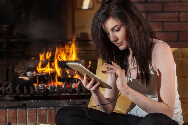 Mujer usando tableta digital por chimenea — Foto de Stock