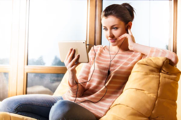 Femme assise dans le salon et écouter de la musique — Photo