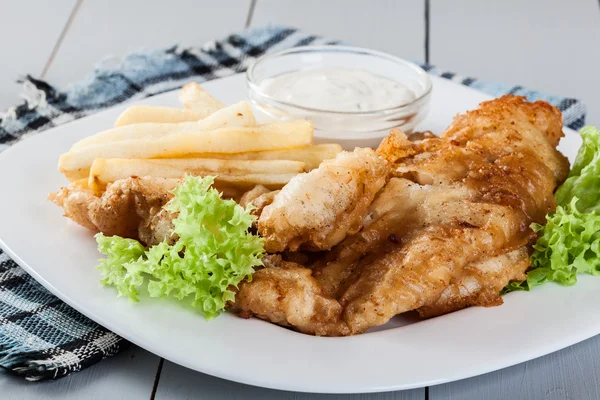 Peixe e batata frita com molho tártaro em um prato — Fotografia de Stock