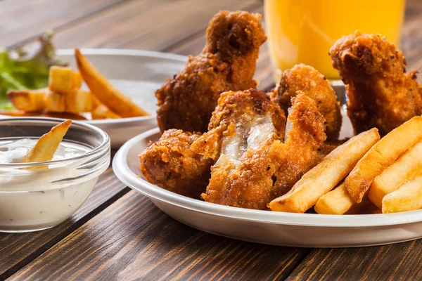 Crisp crunchy chicken wings with chips — Stock Photo, Image