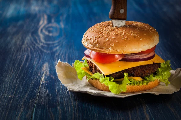 Hamburger pinned with knife — Stock Photo, Image