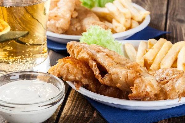 Peixe e batata frita com molho tártaro em um prato — Fotografia de Stock