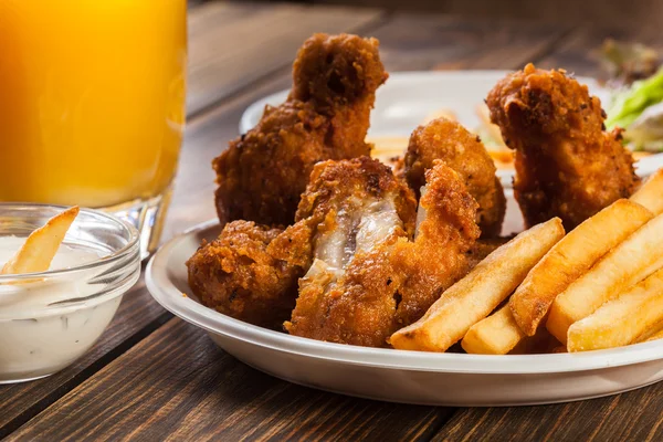 Crisp crunchy chicken wings with chips — Stock Photo, Image