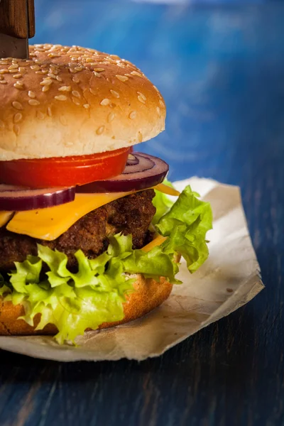 Hamburger przypięty z nożem — Zdjęcie stockowe