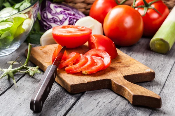Legumes picados: tomates na tábua de corte — Fotografia de Stock
