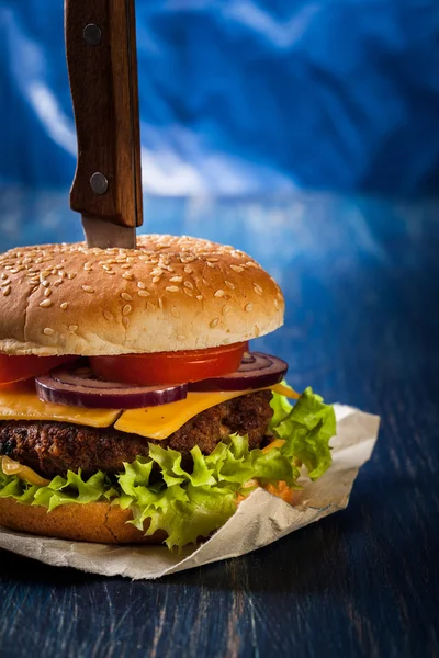 Hamburger przypięty z nożem — Zdjęcie stockowe