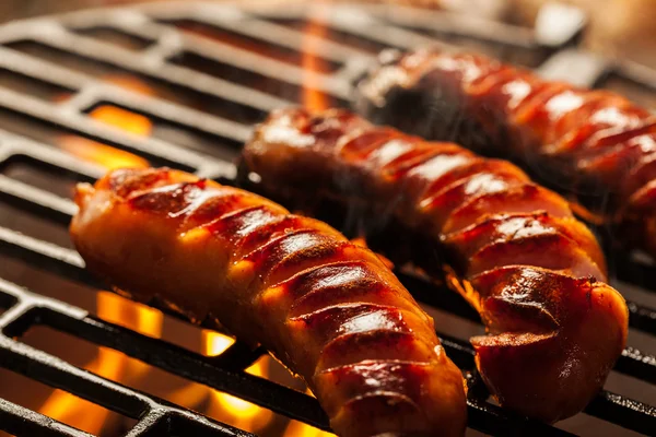 Grilling sausages on barbecue grill