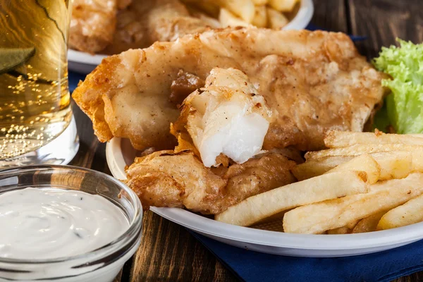 Pesce e patatine fritte con salsa tartara su un piatto — Foto Stock