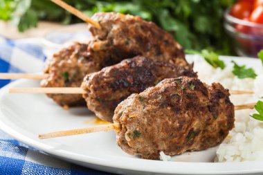 Barbecued kofta with rice on a plate clipart