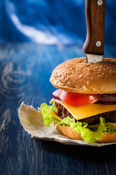 Hamburger bıçak ile tutturulmuş — Stok fotoğraf