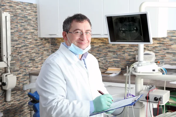 Male dentist holding clipboard — Stock Photo, Image