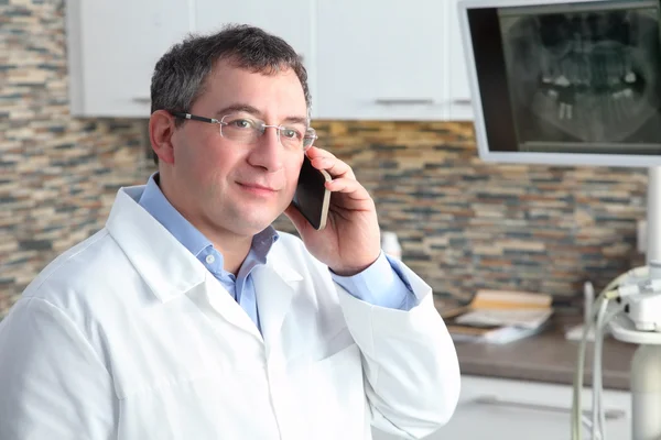 Стоматолог використовує свій мобільний телефон — стокове фото