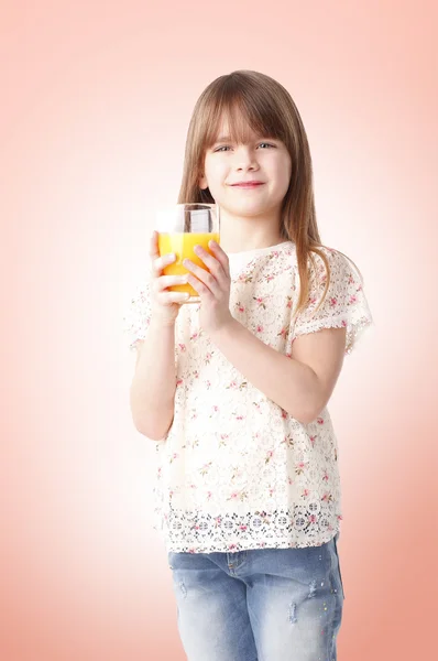 Roztomilá dívka pít pomerančový džus — Stock fotografie