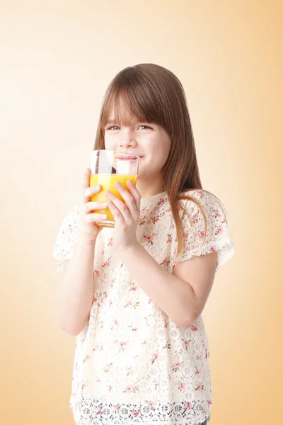 Dziewczyna trzyma kieliszek soku pomarańczowego — Zdjęcie stockowe