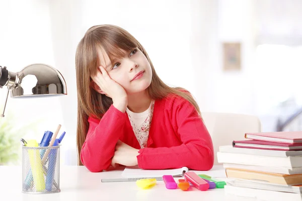 Kleines Mädchen sitzt am Schreibtisch — Stockfoto