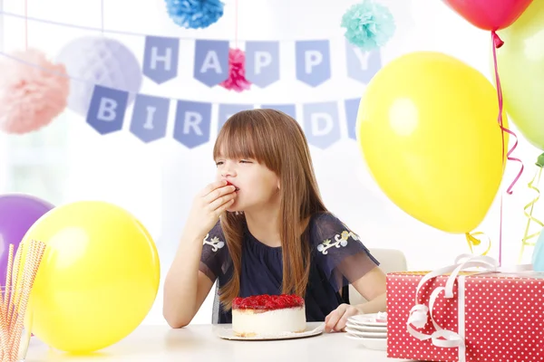 Mädchen sitzt hinter ihrem Kuchen — Stockfoto