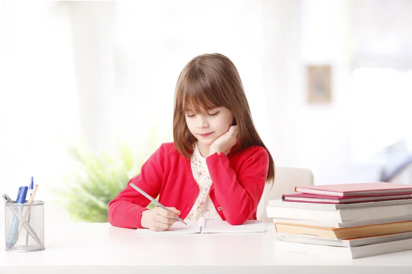Menina escrevendo seu trabalho escolar . — Fotografia de Stock