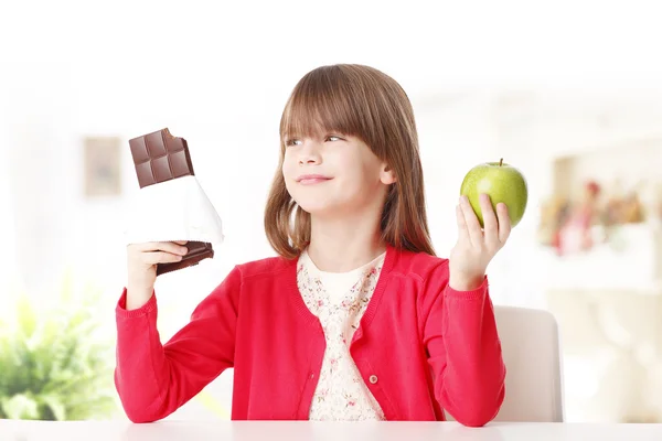 Meisje houdt van chocolade of apple — Stockfoto